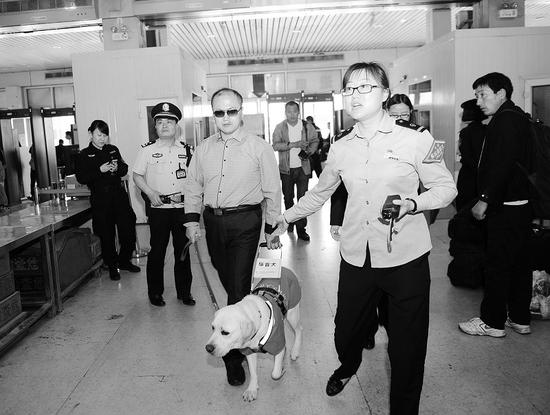 太原火車站工作人員引領導盲犬及其主人進站 記者寇寧攝
