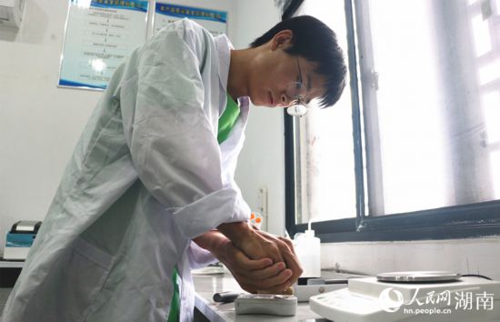 吳健筆在獼猴桃科技小院實(shí)驗(yàn)室測(cè)量水果糖分。 人民網(wǎng)記者 劉賓攝